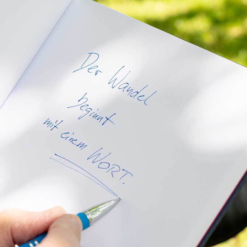 Eintrag in einem Notizbuch: Der Wandel beginnt mit einem Wort.